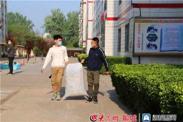 东阿县实验高中校园里,学生们在行李安置点取了行李后,有说有笑的